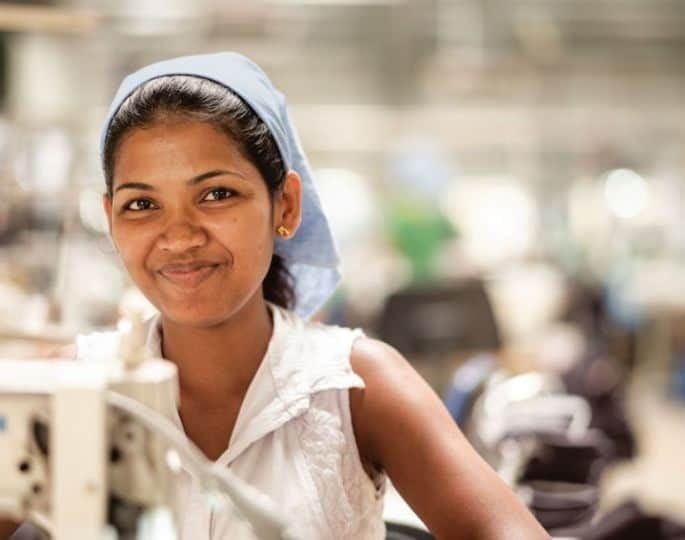 Woman working in a Patagonia clothing factory and smiling