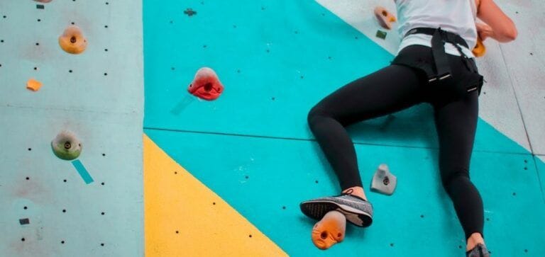 Woman bouldering inside with leggings